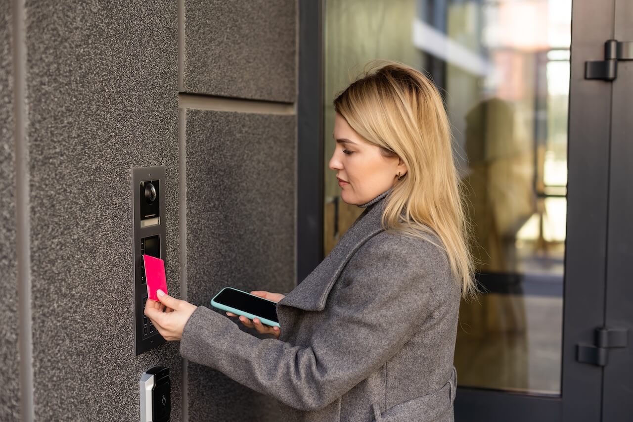woman using intercom at building entrance