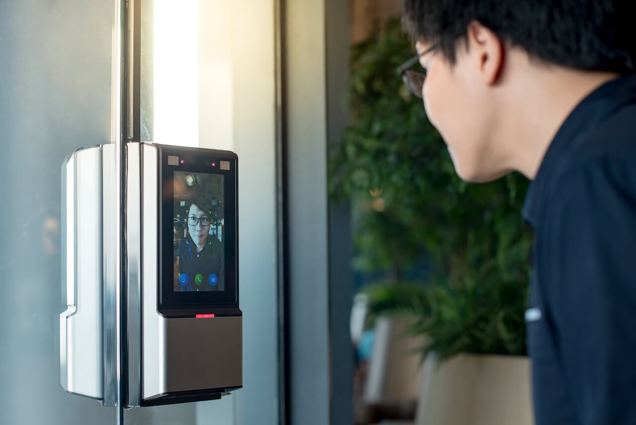 man using face scanner to unlock glass door