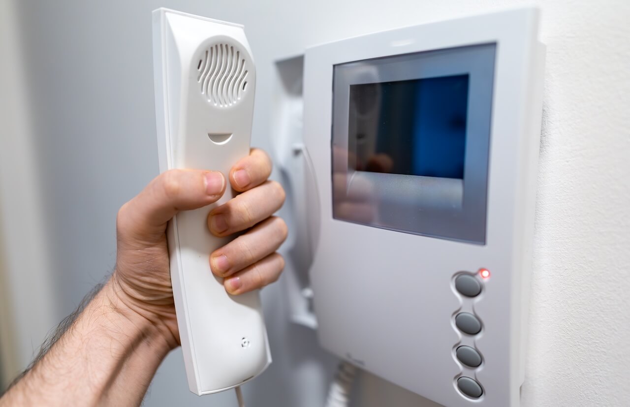 Man Hand Holding White Home Intercom Receiver