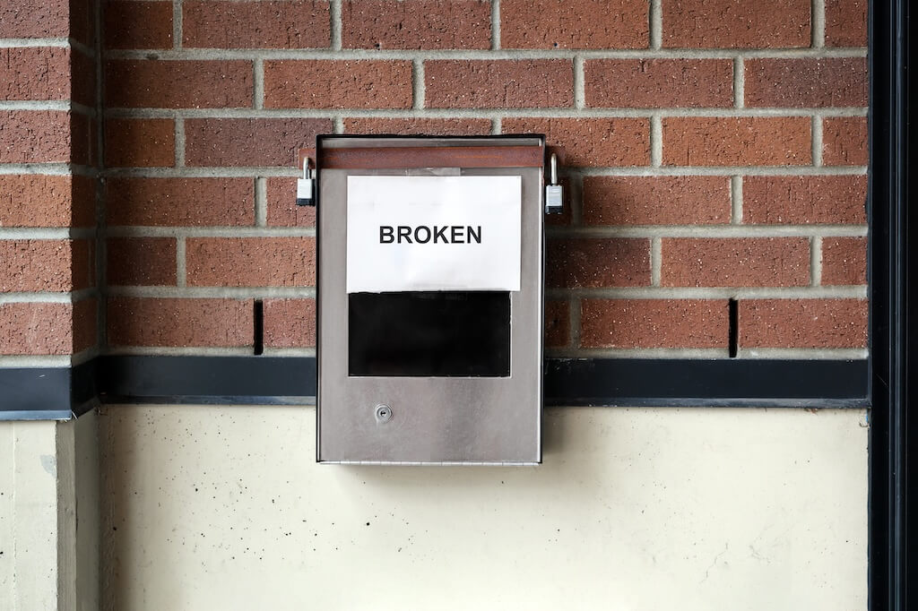 Broken building intercom with paper notice