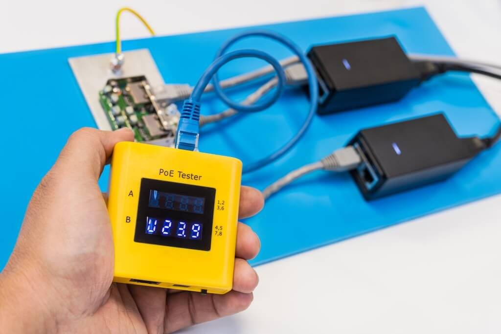 Man measuring the PoE power voltage using data cable tester
