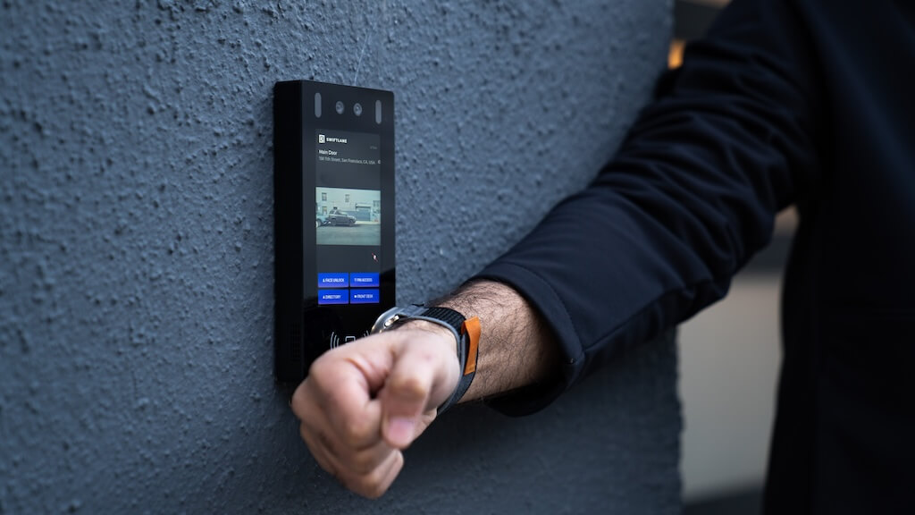 Man using smartwatch at a building intercom