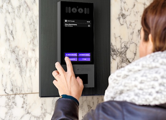 woman using a touchscreen intercom system