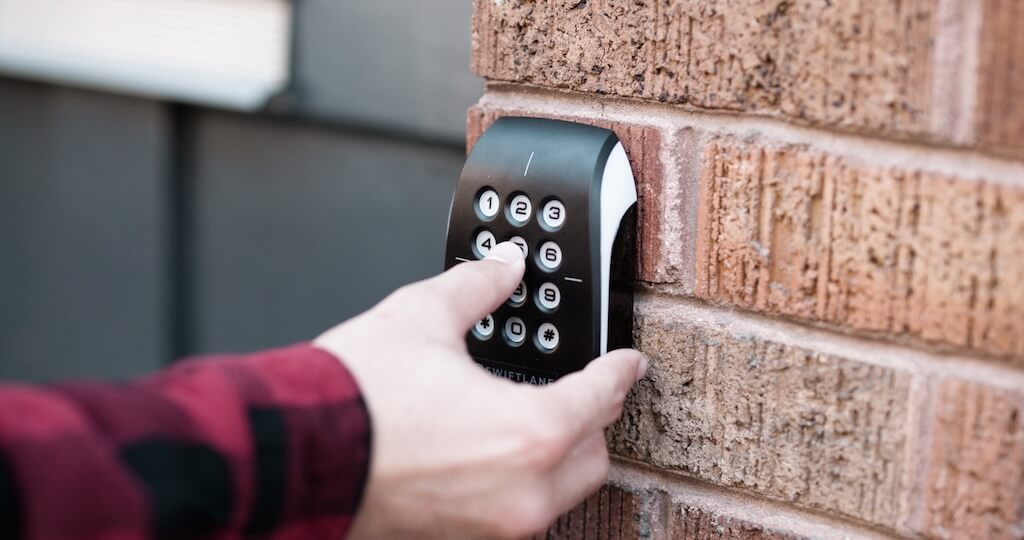 Man pressing keypad buttons on building access control system