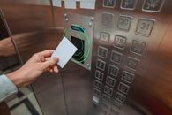 person using a key card in an elevator