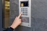 Close-up of a hand entering a code on a modern video intercom