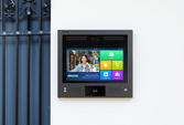 Akuvox X916 intercom mounted on a wall next to an apartment entrance