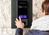 woman using a touchscreen intercom system