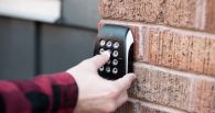 Man pressing keypad buttons on building access control system
