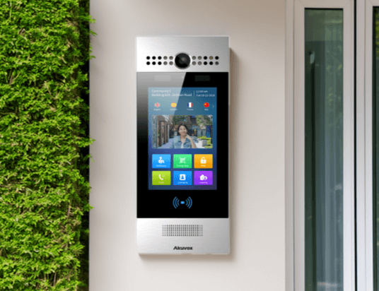 Akuvox R29 intercom mounted on a wall beside a glass door entrance