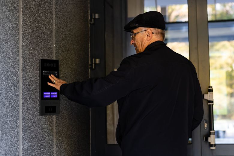 elderly person using swiftlane video intercom at building entry